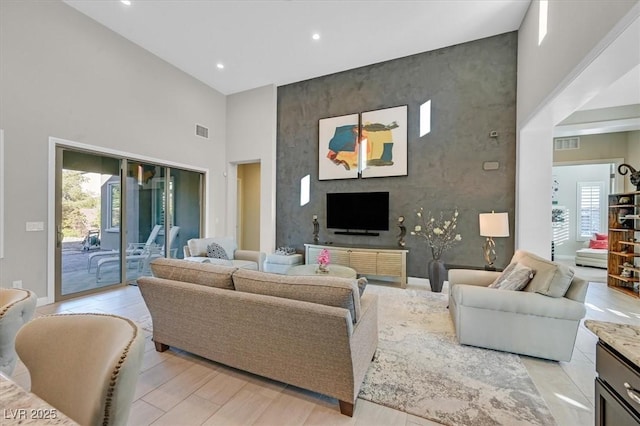 living room with light hardwood / wood-style flooring and a high ceiling