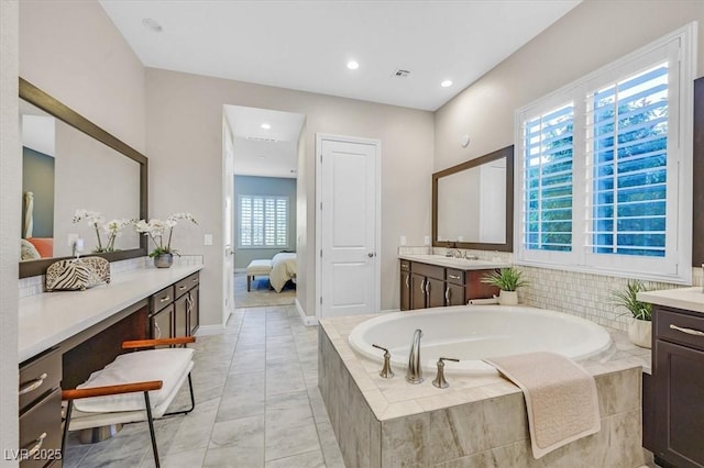 bathroom with vanity and a relaxing tiled tub