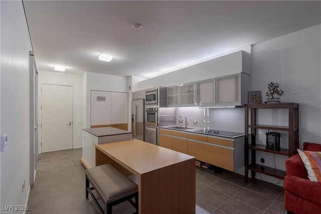 kitchen featuring tasteful backsplash, stainless steel appliances, sink, a kitchen island, and a breakfast bar area