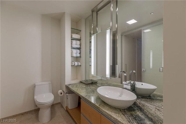 bathroom featuring toilet, built in shelves, vanity, and tile patterned floors