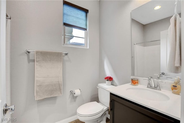 bathroom with a shower, vanity, and toilet