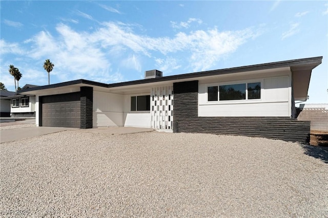 ranch-style house featuring a garage and central AC unit