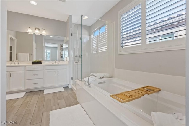 bathroom with vanity and shower with separate bathtub