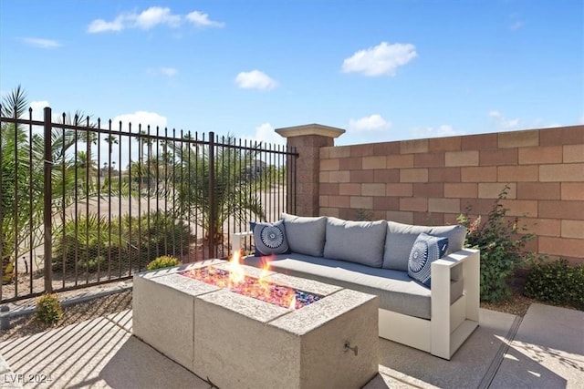 view of patio with an outdoor living space with a fire pit