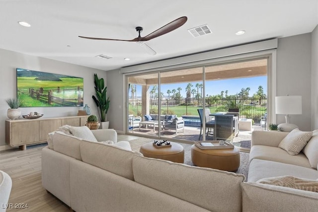 living room featuring ceiling fan and light hardwood / wood-style flooring