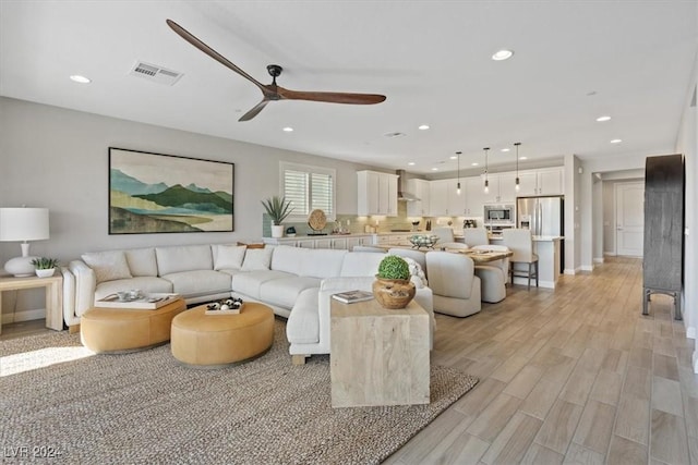 living room featuring ceiling fan and light hardwood / wood-style flooring