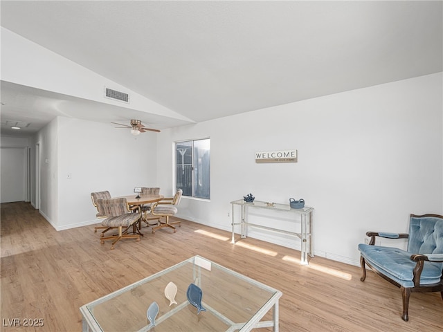 living area featuring light hardwood / wood-style flooring, vaulted ceiling, and ceiling fan