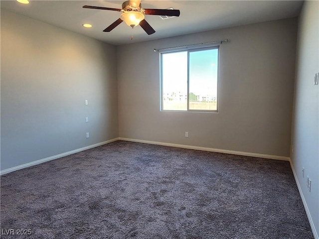 empty room with ceiling fan and dark carpet