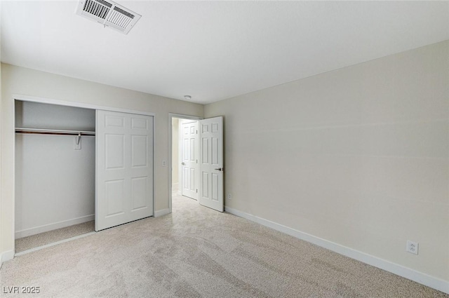 unfurnished bedroom with a closet and light colored carpet