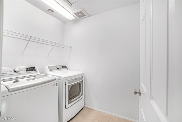 laundry area with light tile patterned floors and washing machine and clothes dryer