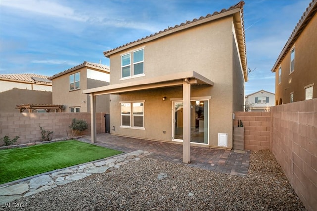 back of house with a lawn and a patio area