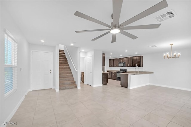 unfurnished living room with light tile patterned flooring and ceiling fan with notable chandelier