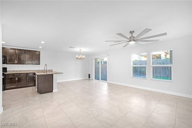 unfurnished living room with sink, light tile patterned flooring, and ceiling fan with notable chandelier