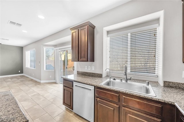 kitchen featuring stainless steel dishwasher, light tile patterned floors, and sink