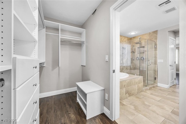 interior space with wood-type flooring and shower with separate bathtub