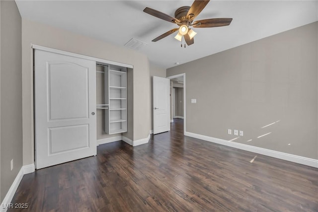 unfurnished bedroom featuring ceiling fan, dark hardwood / wood-style flooring, and a closet