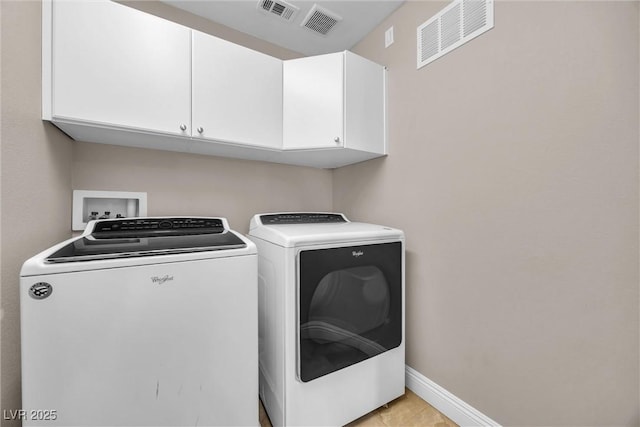 laundry area featuring cabinets, independent washer and dryer, and light tile patterned flooring