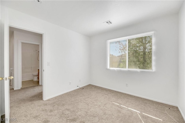 unfurnished room featuring light carpet