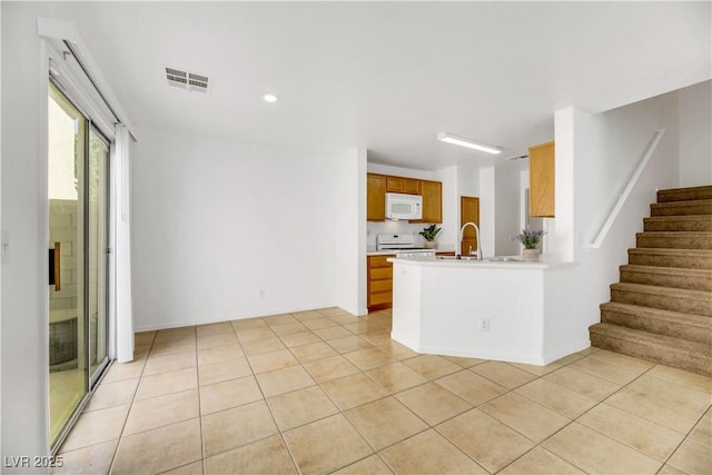 interior space featuring white appliances, sink, and light tile patterned floors