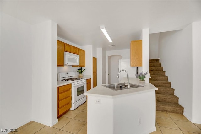 kitchen featuring white appliances, sink, and light tile patterned floors