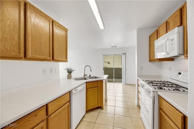 kitchen with kitchen peninsula, light tile patterned floors, white appliances, and sink