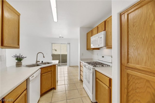 kitchen featuring sink, light tile patterned floors, and white appliances