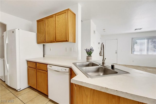 kitchen featuring white appliances, sink, and light tile patterned floors