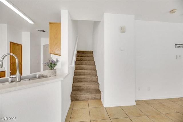 stairway with tile patterned floors and sink