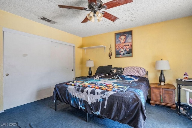 carpeted bedroom with a textured ceiling and ceiling fan