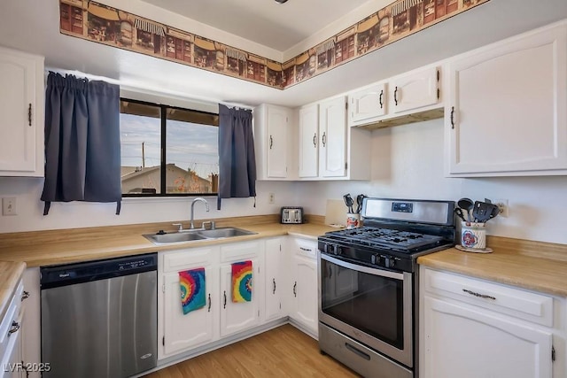 kitchen featuring light wood-type flooring, white cabinetry, sink, and appliances with stainless steel finishes