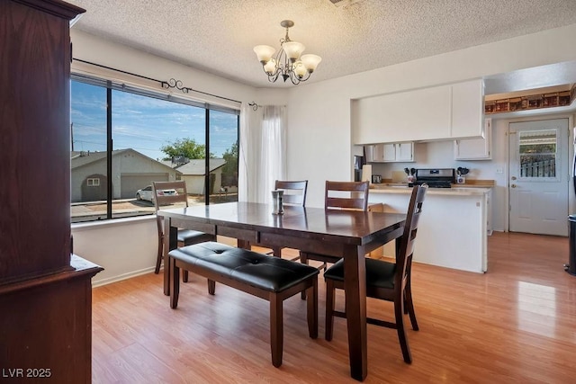 3609 Woodglen Ct, Las Vegas, NV 89108 - dining room with a chandelier, light wood-style flooring, and a textured ceiling