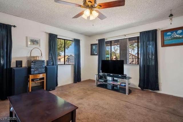 living room featuring ceiling fan, carpet, and a textured ceiling