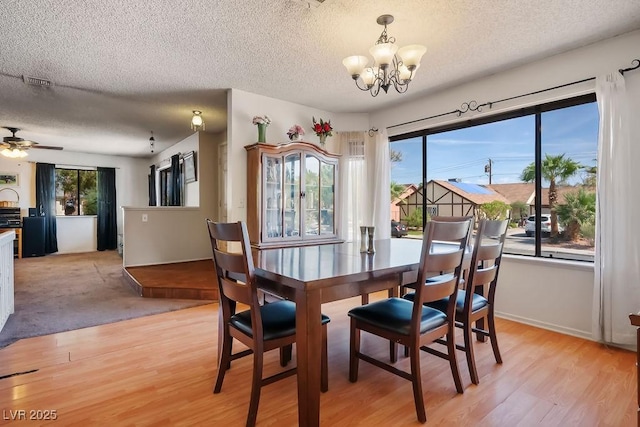 3609 Woodglen Ct, Las Vegas, NV 89108 - dining room featuring a textured ceiling, a chandelier, light wood finished floors, and a ceiling fan