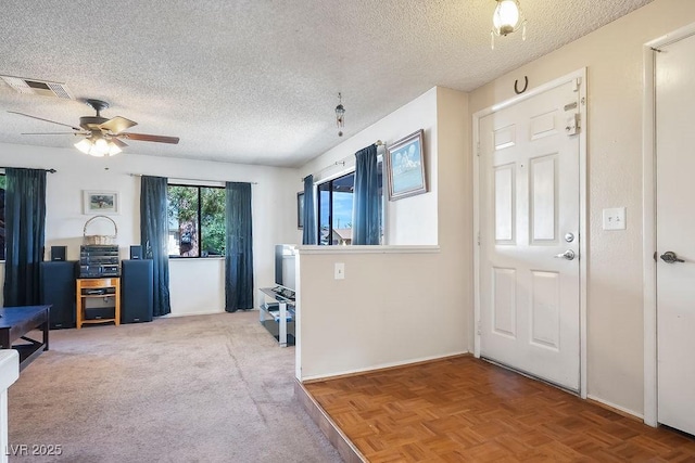 foyer with ceiling fan, parquet flooring, and a textured ceiling