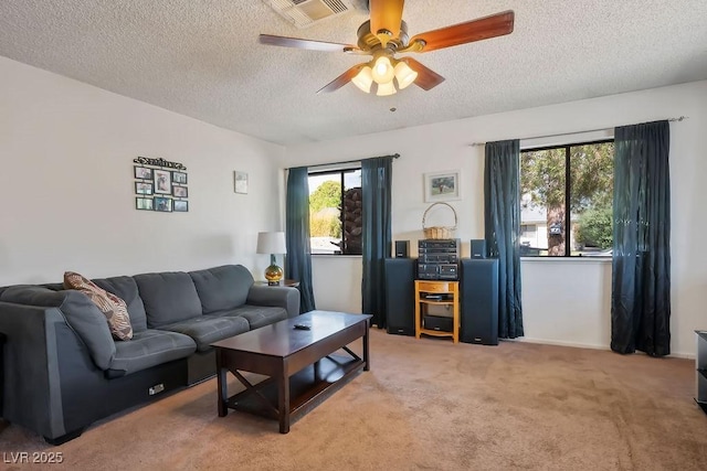 carpeted living room with ceiling fan and a textured ceiling