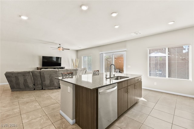 kitchen with dishwasher, a center island with sink, sink, ceiling fan, and light tile patterned floors