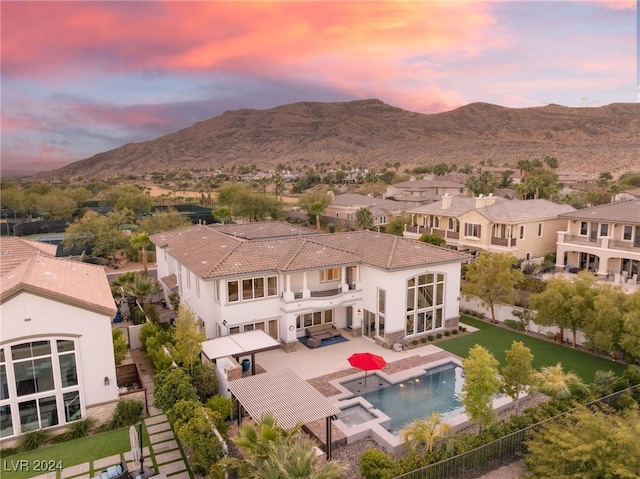 exterior space featuring a fenced in pool, a patio area, a mountain view, and a balcony