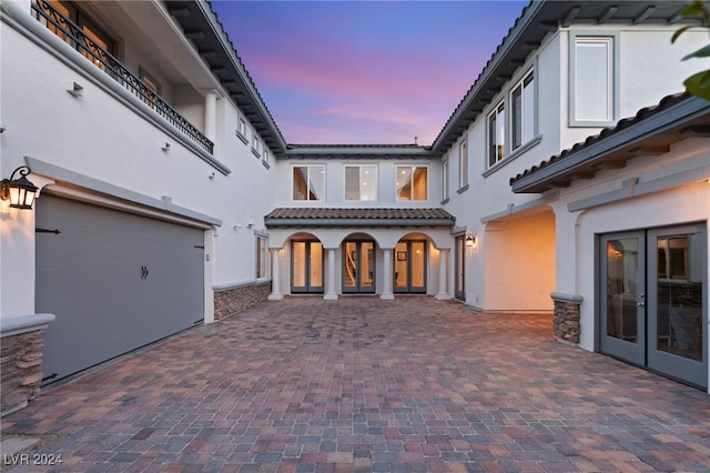 patio terrace at dusk featuring french doors