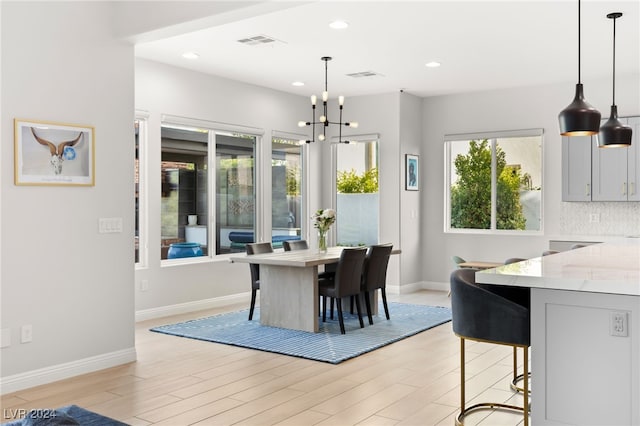 dining space featuring light hardwood / wood-style flooring and an inviting chandelier