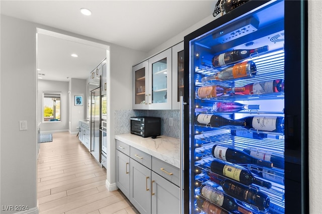 kitchen featuring gray cabinets, light stone counters, and light hardwood / wood-style floors