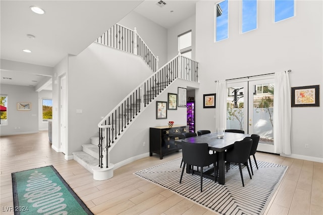 dining area featuring french doors, a high ceiling, and light wood-type flooring