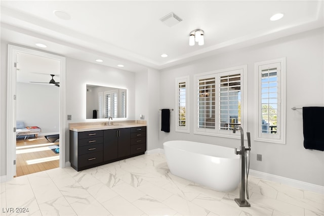 bathroom featuring vanity, ceiling fan, and a tub to relax in