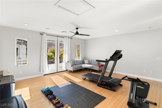 workout room with ceiling fan and light hardwood / wood-style flooring