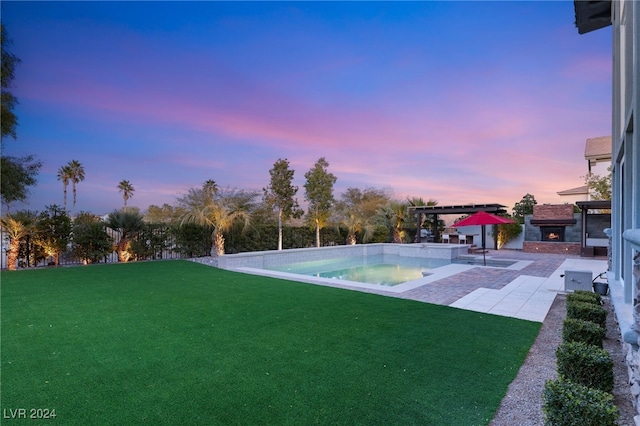 yard at dusk featuring a pergola and a patio area