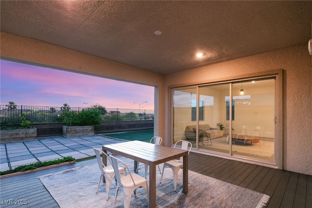 deck at dusk featuring a patio