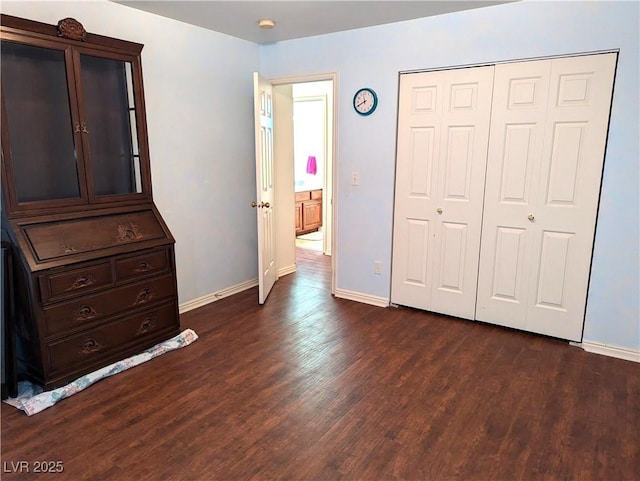 unfurnished bedroom with dark hardwood / wood-style floors and a closet