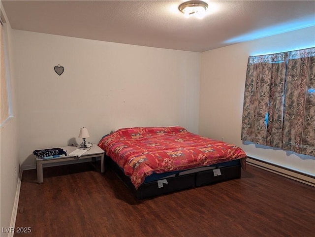 bedroom with hardwood / wood-style flooring and baseboard heating