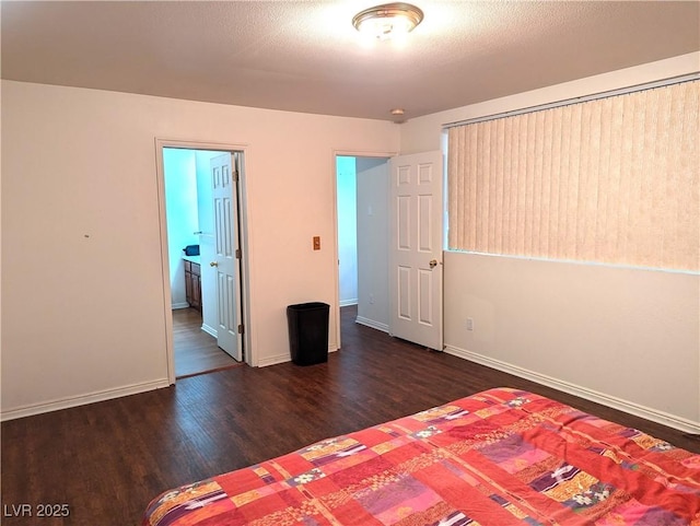 unfurnished bedroom with a textured ceiling and dark hardwood / wood-style flooring