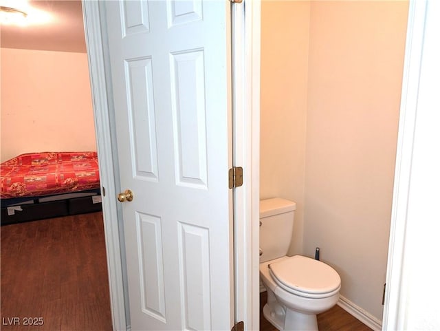 bathroom featuring hardwood / wood-style flooring and toilet