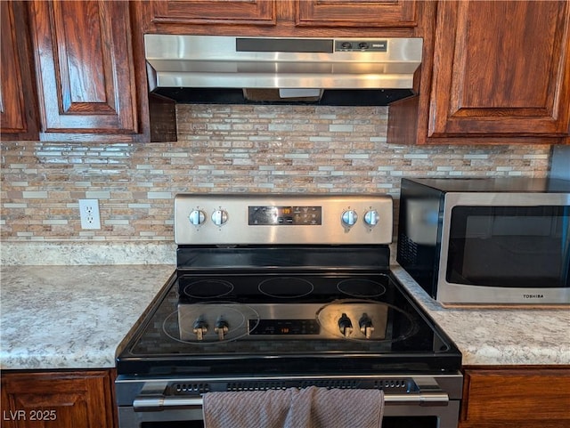 kitchen featuring stainless steel appliances, ventilation hood, backsplash, and light stone counters